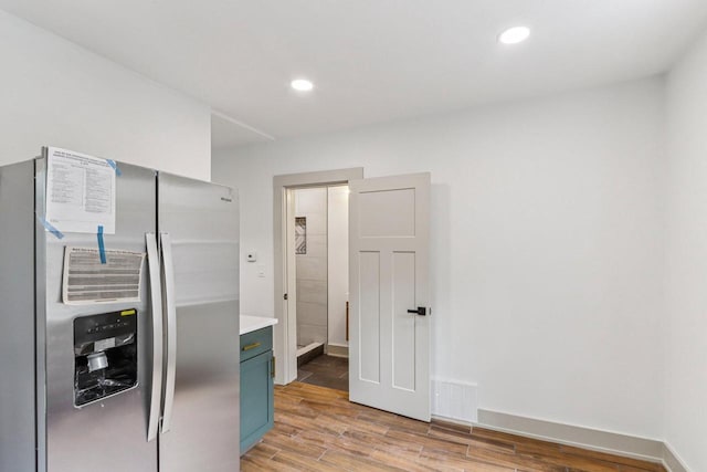 1617 69th St, Kenosha, WI 53143 - kitchen with stainless steel refrigerator with ice dispenser, light wood-style floors, blue cabinetry, light countertops, and recessed lighting
