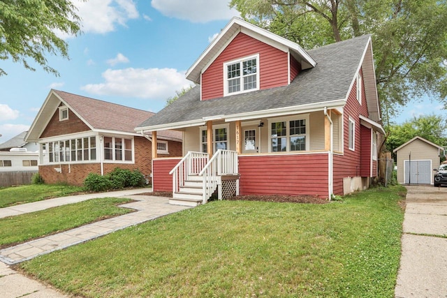 1617 69th St, Kenosha, WI 53143 - bungalow-style house with covered porch, a front lawn, a storage unit, a shingled roof, and driveway