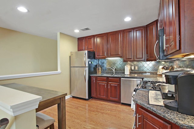 408 55th St Unit B, Kenosha, WI 53140 - kitchen featuring stainless steel appliances, dark brown cabinets, backsplash, light wood-type flooring, and recessed lighting