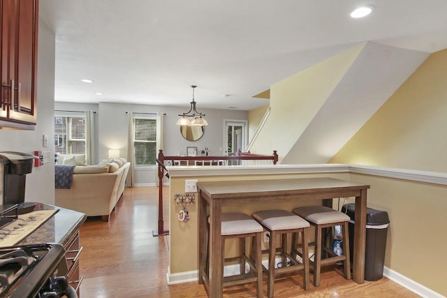 408 55th St Unit B, Kenosha, WI 53140 - kitchen with light wood-style floors, a kitchen breakfast bar, open floor plan, pendant lighting, and recessed lighting