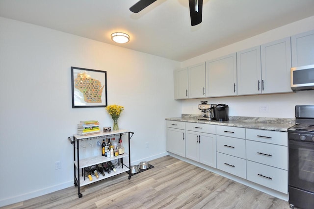 3313 S Delaware Ave, Milwaukee, WI 53207 - kitchen with black range with electric cooktop, stainless steel microwave, a ceiling fan, and light wood-style flooring
