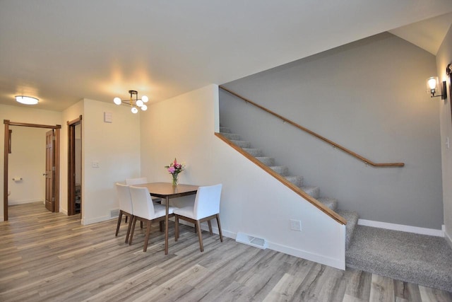 3313 S Delaware Ave, Milwaukee, WI 53207 - dining space with wood finished floors, stairs, and a chandelier