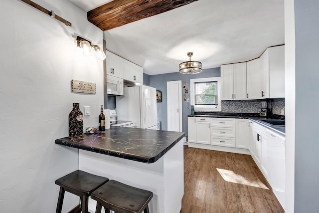 517 12th Ave, Green Bay, WI 54303 - kitchen with white appliances, a peninsula, dark wood-style floors, white cabinetry, and beam ceiling