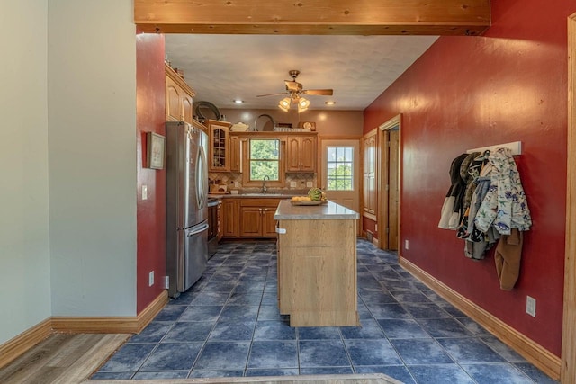 1915 7th St, Monroe, WI 53566 - kitchen with freestanding refrigerator, a center island, a ceiling fan, light countertops, and glass insert cabinets