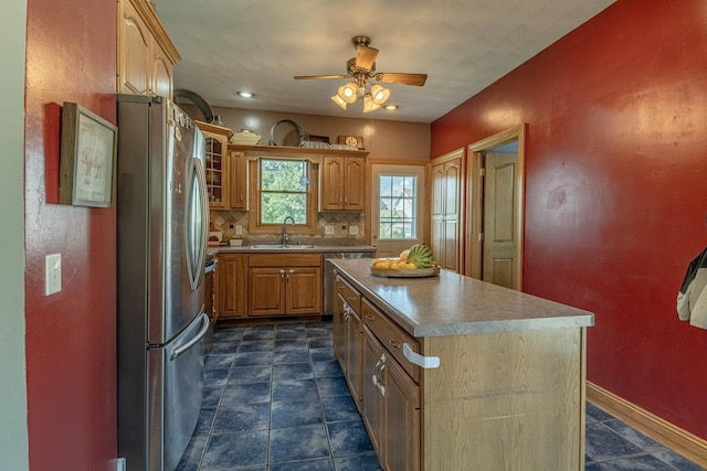 1915 7th St, Monroe, WI 53566 - kitchen with stainless steel appliances, a ceiling fan, a center island, glass insert cabinets, and light countertops