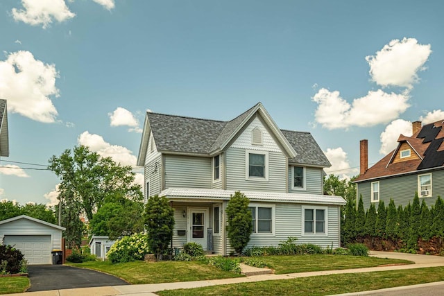 1915 7th St, Monroe, WI 53566 - victorian-style house featuring an outdoor structure, a detached garage, a front lawn, and roof with shingles