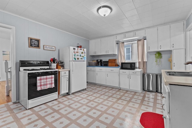 624 W 8th Ave, Oshkosh, WI 54902 - kitchen featuring gas stove, freestanding refrigerator, black microwave, crown molding, and light flooring