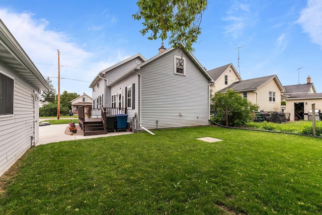 624 W 8th Ave, Oshkosh, WI 54902 - rear view of house featuring a yard, a deck, a patio area, and a chimney