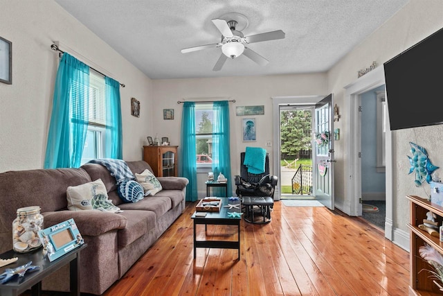 624 W 8th Ave, Oshkosh, WI 54902 - living room featuring ceiling fan, light wood-style floors, and a textured ceiling