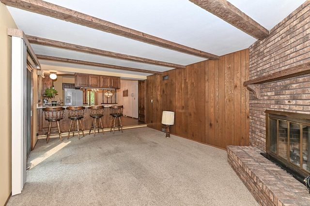 7701 W Coventry Dr, Franklin, WI 53132 - unfurnished living room featuring beamed ceiling, light carpet, wooden walls, and a fireplace