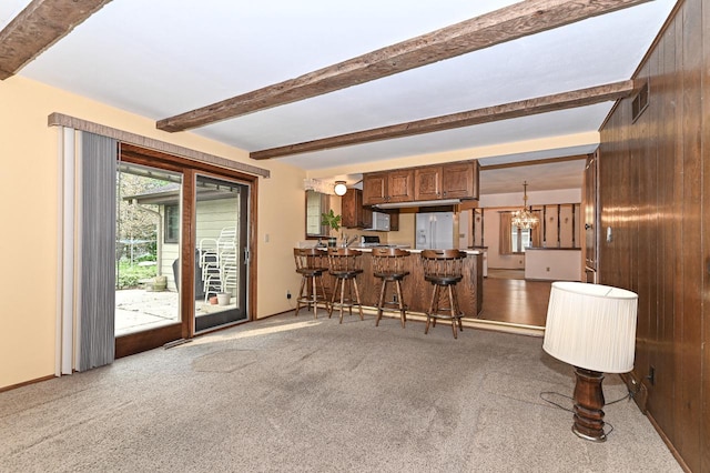 7701 W Coventry Dr, Franklin, WI 53132 - kitchen with carpet, beam ceiling, a kitchen breakfast bar, a peninsula, and white fridge with ice dispenser