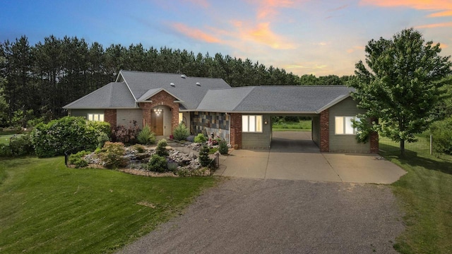 1022 Cortland Ln, Stevens Point, WI 54482 - view of front of house with driveway, a front lawn, brick siding, and an attached carport