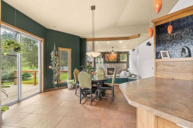 1022 Cortland Ln, Stevens Point, WI 54482 - dining area featuring a fireplace, light tile patterned floors, a ceiling fan, and vaulted ceiling