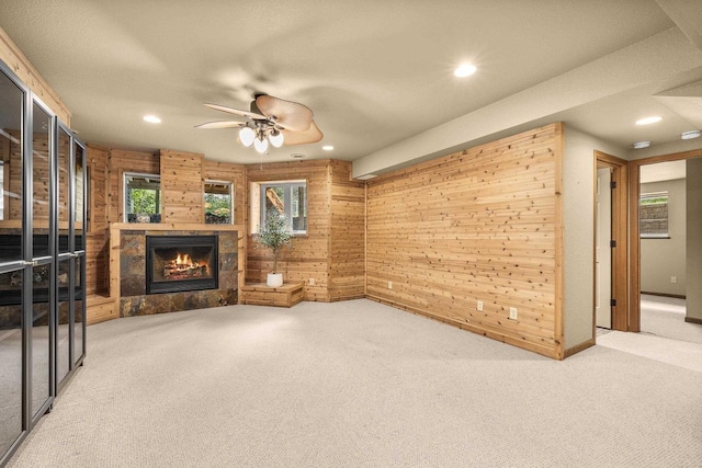 1022 Cortland Ln, Stevens Point, WI 54482 - unfurnished living room featuring wooden walls, carpet, a tile fireplace, recessed lighting, and a ceiling fan