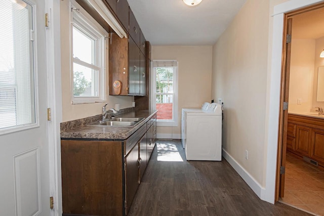 604 Wilson St, Winona, MN 55987 - kitchen featuring washer and clothes dryer, dark wood-type flooring, dark brown cabinetry, and dark countertops