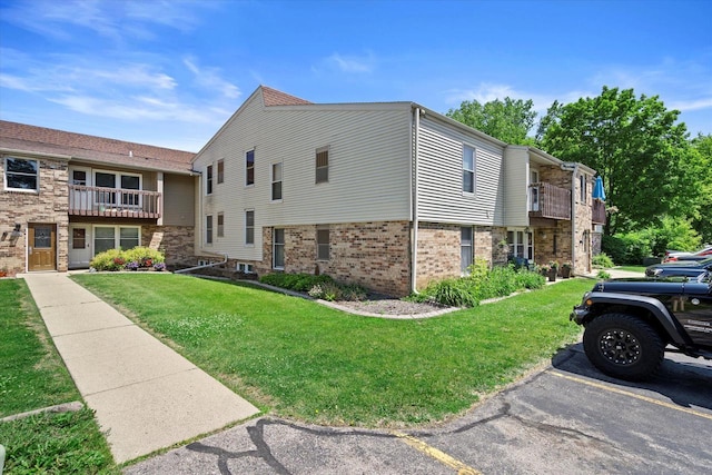 N114W16680 Crown Dr Unit 7, Germantown, WI 53022 - view of side of home featuring brick siding and a yard