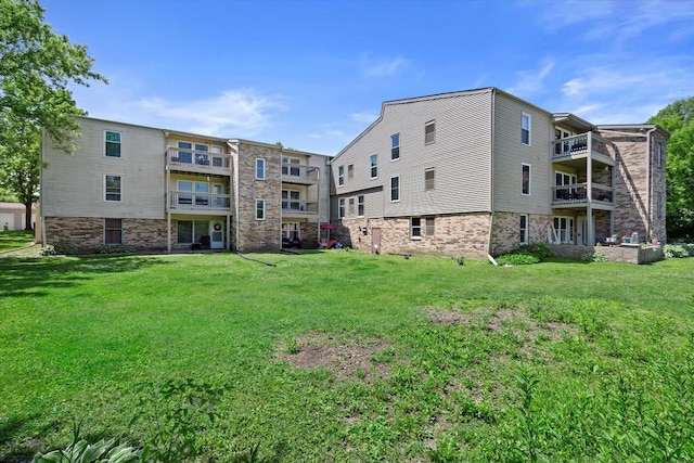N114W16680 Crown Dr Unit 7, Germantown, WI 53022 - rear view of property featuring a balcony, a yard, and brick siding