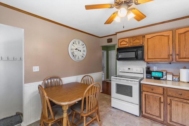 4502 W Sumac Pl, Milwaukee, WI 53219 - kitchen with electric range, black microwave, light countertops, crown molding, and a wainscoted wall