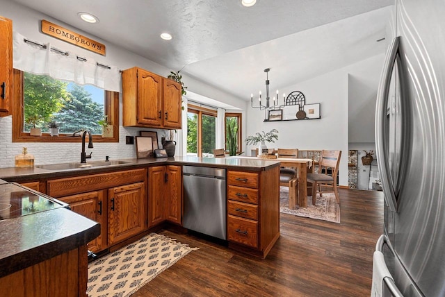 4814 Placid Way, New Franken, WI 54229 - kitchen featuring stainless steel appliances, brown cabinets, a peninsula, dark countertops, and lofted ceiling