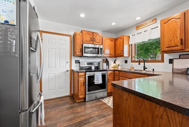 4814 Placid Way, New Franken, WI 54229 - kitchen featuring appliances with stainless steel finishes, dark countertops, decorative backsplash, brown cabinets, and dark wood-style floors