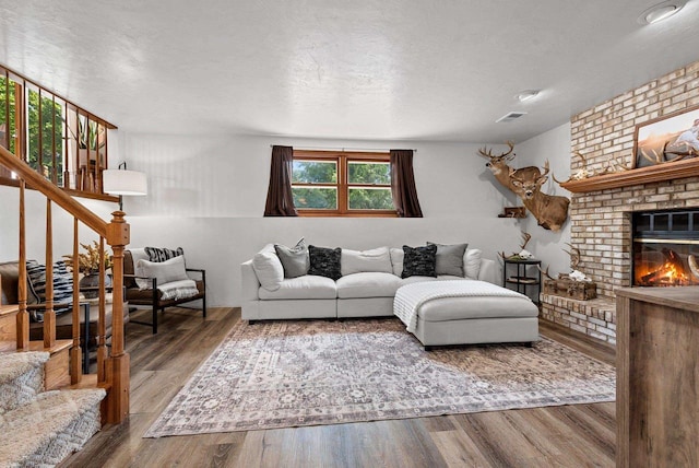 4814 Placid Way, New Franken, WI 54229 - living room with stairway, wood finished floors, a brick fireplace, and a textured ceiling