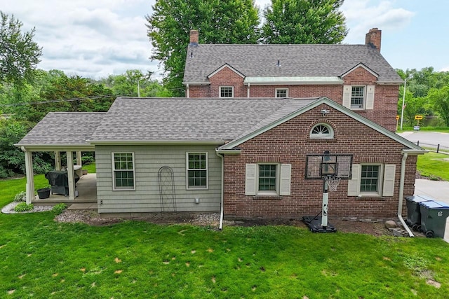 511 Wisconsin River Dr, Port Edwards, WI 54469 - rear view of property featuring a chimney, a yard, brick siding, and roof with shingles