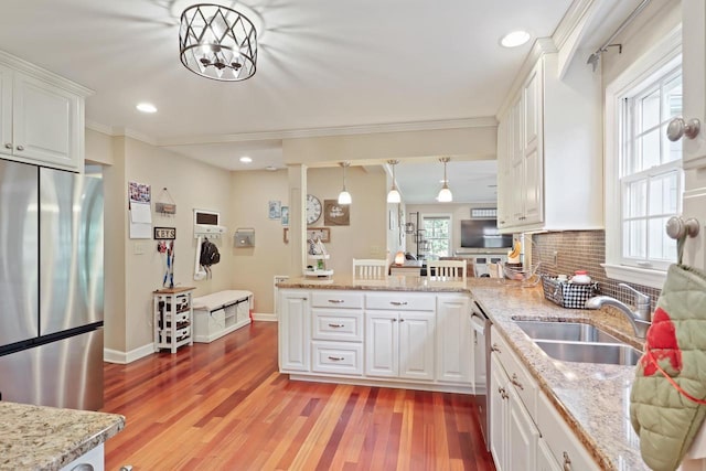 511 Wisconsin River Dr, Port Edwards, WI 54469 - kitchen with appliances with stainless steel finishes, a peninsula, white cabinetry, ornamental molding, and decorative backsplash