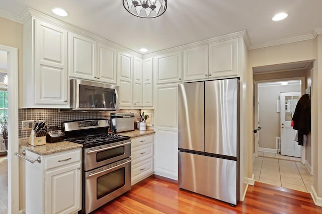 511 Wisconsin River Dr, Port Edwards, WI 54469 - kitchen featuring appliances with stainless steel finishes, crown molding, white cabinetry, backsplash, and recessed lighting