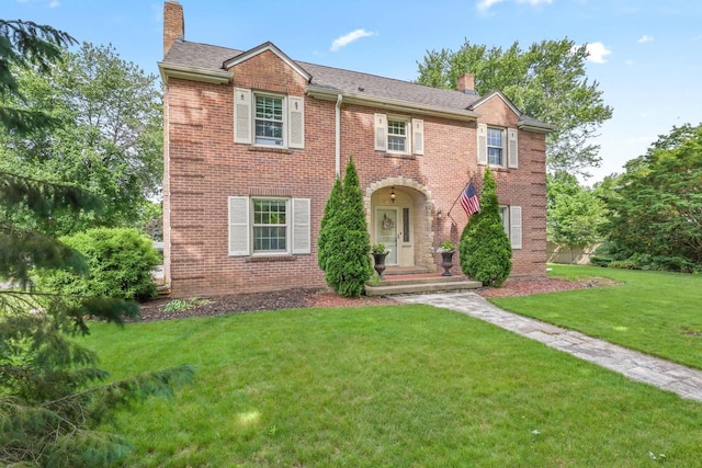 511 Wisconsin River Dr, Port Edwards, WI 54469 - view of front of house with a chimney, brick siding, and a front lawn