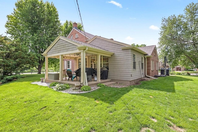 511 Wisconsin River Dr, Port Edwards, WI 54469 - rear view of property featuring a yard, a chimney, a patio, and a shingled roof