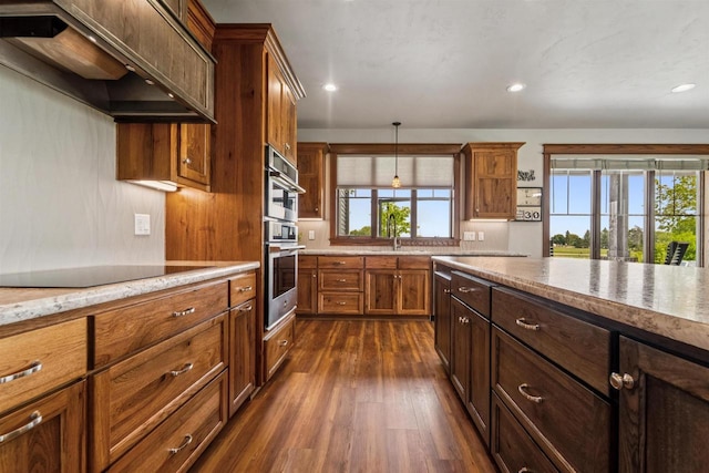 W9336 Lucy Ln, Hortonville, WI 54944 - kitchen with custom exhaust hood, dark wood finished floors, recessed lighting, hanging light fixtures, and brown cabinetry