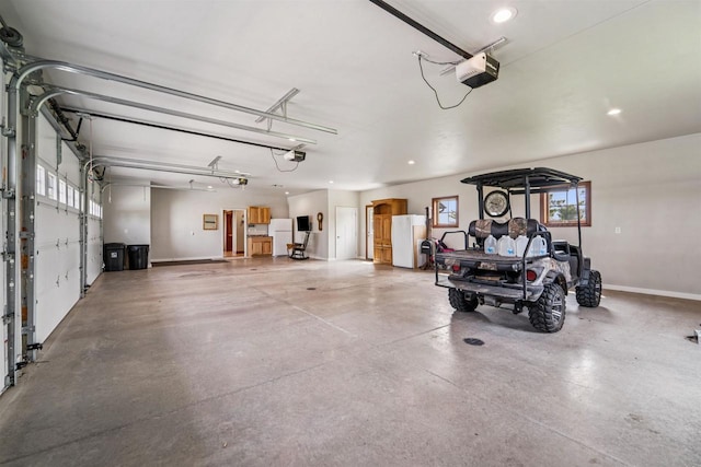 W9336 Lucy Ln, Hortonville, WI 54944 - garage featuring a garage door opener, freestanding refrigerator, and recessed lighting