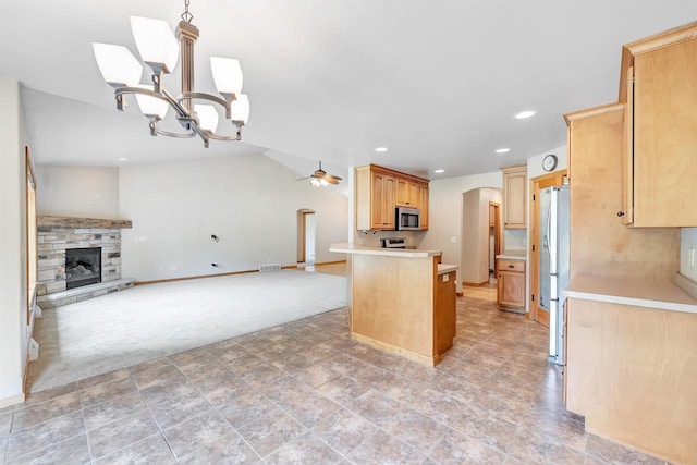 665 Black Earth Dr, De Pere, WI 54115 - kitchen with stainless steel appliances, open floor plan, a chandelier, arched walkways, and a stone fireplace