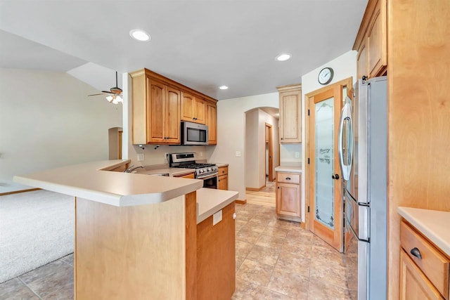 665 Black Earth Dr, De Pere, WI 54115 - kitchen with appliances with stainless steel finishes, a peninsula, arched walkways, light countertops, and recessed lighting