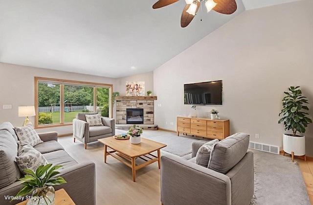 665 Black Earth Dr, De Pere, WI 54115 - living room with ceiling fan, a stone fireplace, light wood-type flooring, and high vaulted ceiling