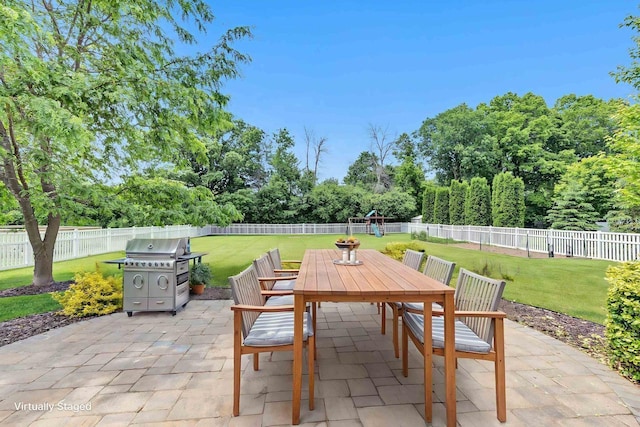 665 Black Earth Dr, De Pere, WI 54115 - fenced backyard with outdoor dining area, a patio, area for grilling, and view of wooded area