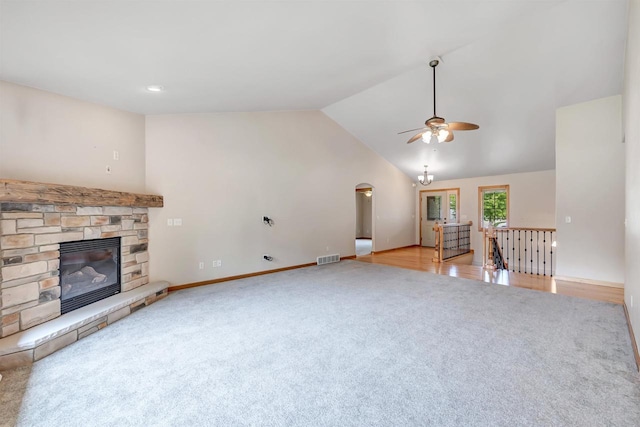 665 Black Earth Dr, De Pere, WI 54115 - unfurnished living room with carpet floors, a ceiling fan, arched walkways, a fireplace, and vaulted ceiling