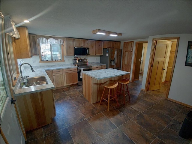 1959 79th St, Balsam Lake, WI 54853 - kitchen with appliances with stainless steel finishes, a kitchen island, light countertops, and a breakfast bar