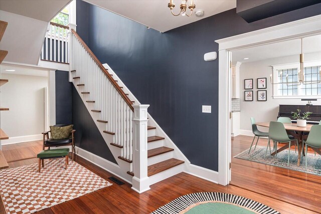 225 8th St, South Street, La Crosse, WI 54601 - stairs featuring wood finished floors and a chandelier