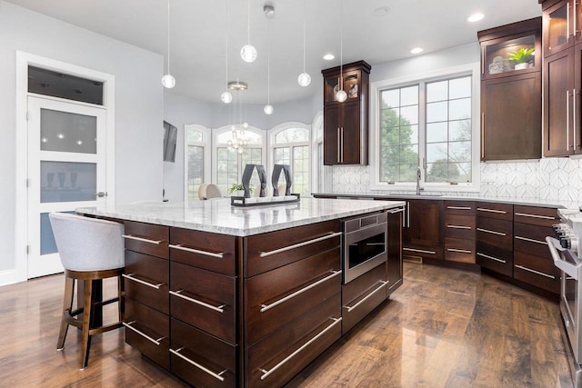 W1977 Center Valley Rd, Kaukauna, WI 54130 - kitchen with dark wood-style flooring, stainless steel microwave, backsplash, a center island, and recessed lighting