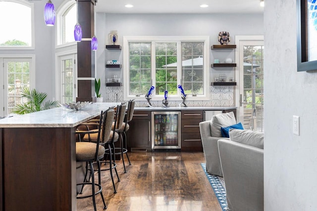 W1977 Center Valley Rd, Kaukauna, WI 54130 - kitchen with beverage cooler, open shelves, dark brown cabinetry, light countertops, and a kitchen bar