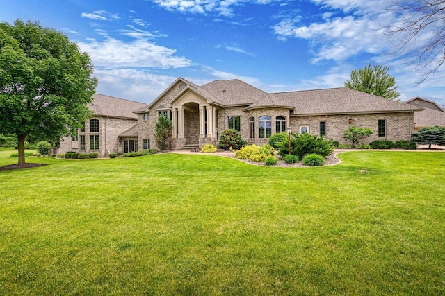 W1977 Center Valley Rd, Kaukauna, WI 54130 - french country home with a front yard, brick siding, and a shingled roof