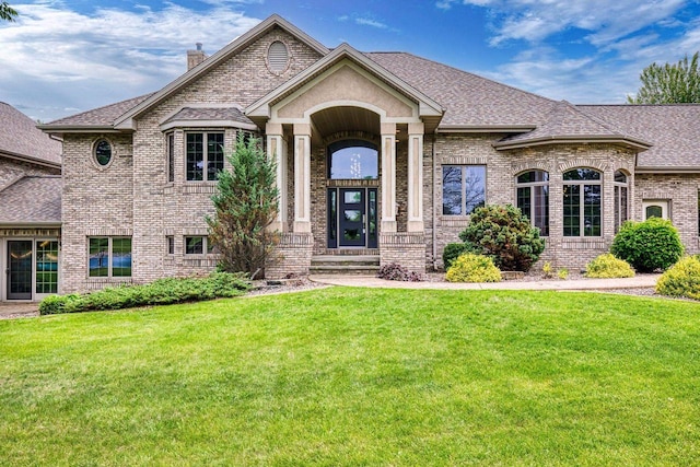 W1977 Center Valley Rd, Kaukauna, WI 54130 - french provincial home with brick siding, roof with shingles, a front lawn, and a chimney