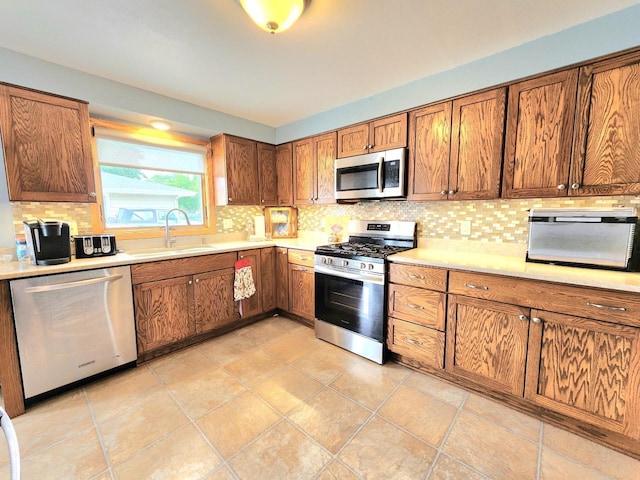 1239 Columbus Ave, Sheboygan, WI 53083 - kitchen with stainless steel appliances, tasteful backsplash, brown cabinets, and light countertops