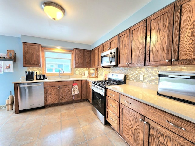 1239 Columbus Ave, Sheboygan, WI 53083 - kitchen with appliances with stainless steel finishes, decorative backsplash, light countertops, and brown cabinetry