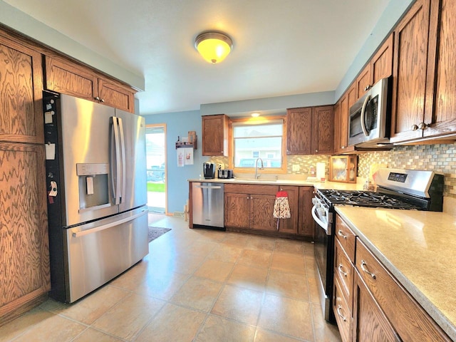 1239 Columbus Ave, Sheboygan, WI 53083 - kitchen with stainless steel appliances, decorative backsplash, brown cabinetry, and light countertops