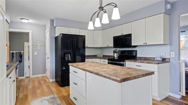 12901 7th St, Osseo, WI 54758 - kitchen featuring black appliances, light wood-type flooring, white cabinets, a center island, and dark countertops
