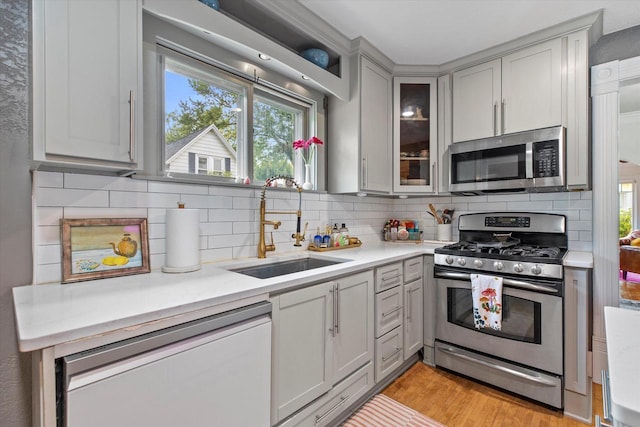 128 Maple Ave, Hartland, WI 53029 - kitchen with stainless steel appliances, light countertops, tasteful backsplash, and gray cabinets