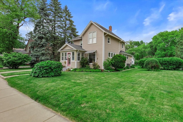 128 Maple Ave, Hartland, WI 53029 - traditional-style house featuring a chimney and a front lawn