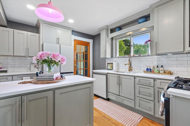 128 Maple Ave, Hartland, WI 53029 - kitchen featuring fridge, dishwashing machine, gray cabinetry, light countertops, and backsplash